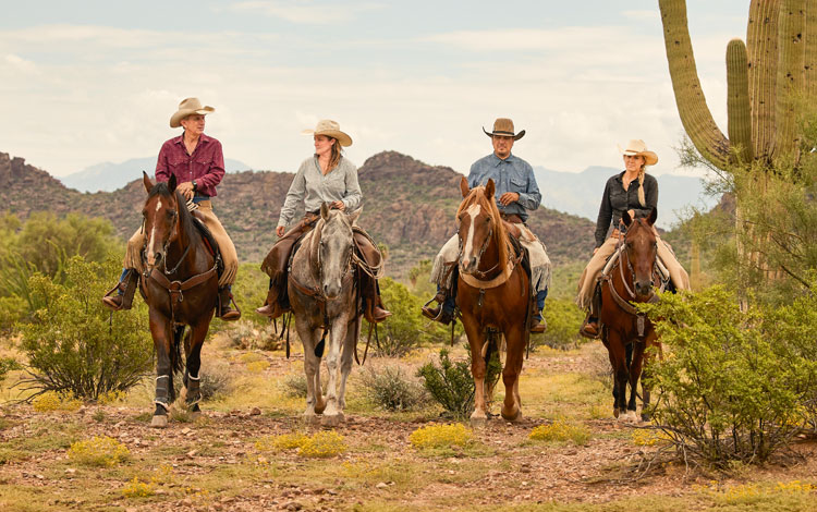 Un grupo de personas a caballo en el desierto.